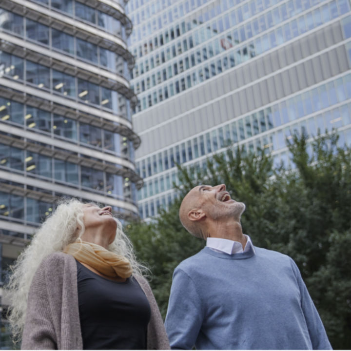 Woman and man outside looking up on a office building - KONE Services
